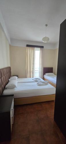 a bedroom with two beds and a window at Kaya by Keshtjella in Durrës