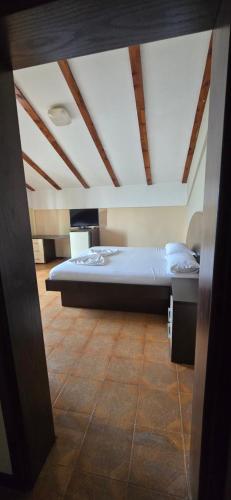 a large bed in a room with a ceiling at Kaya by Keshtjella in Durrës