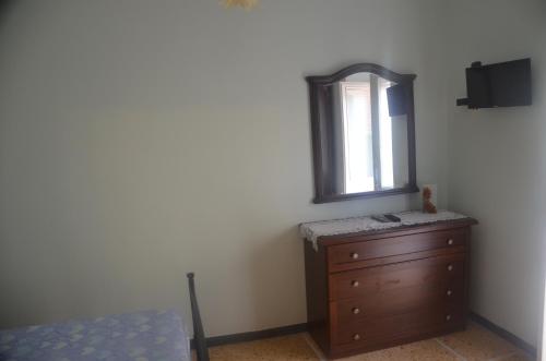 a bedroom with a dresser and a mirror at Della Pace Apartment in Tellaro