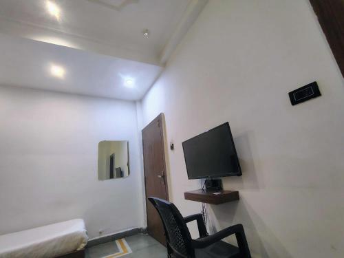 Kleines Zimmer mit einem TV und 2 Stühlen in der Unterkunft Hotel O Karond Square Bus Terminal Bhopal Formerly Hotel Munmun in Bhopal