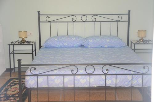 a bed with a metal frame and two night stands at Della Pace Apartment in Tellaro