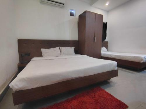 1 Schlafzimmer mit 2 Betten und einem roten Teppich in der Unterkunft Hotel O Karond Square Bus Terminal Bhopal Formerly Hotel Munmun in Bhopal