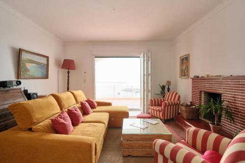 a living room with a couch and a fireplace at Manas Slowliving - Sines in Sines