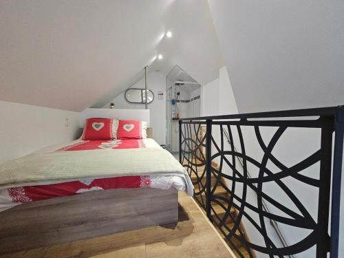 a bedroom with a bed with red pillows on it at O Cottage E Lavisse in Le Nouvion-en-Thiérache