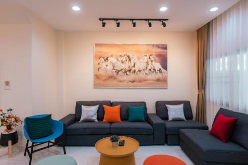 a living room with a couch and a painting on the wall at EXCLUSIVE SUKHUMVIT RESIDENCE, 3 Min BTS, Thonglor, 20 Guests in Bangkok