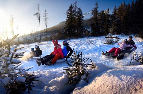 a group of people sitting in the snow at Horská ubytovňa Hrebienok in Smokovce