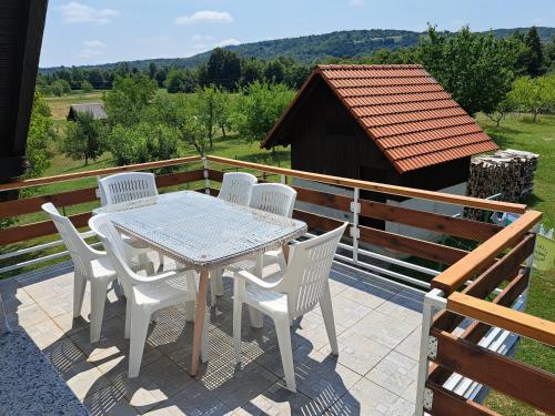 a white table and chairs on a patio with a view at Guesthouse Zafran in Smoljanac