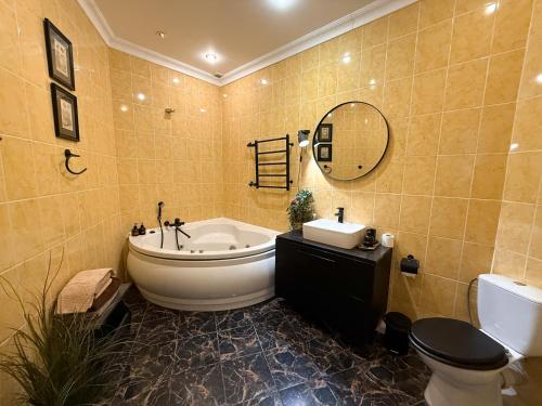 a bathroom with a tub and a toilet and a sink at Kyiv Panna Apartment in Kyiv