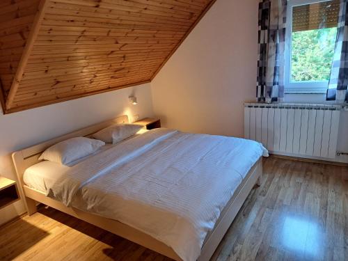 een slaapkamer met een groot bed met een houten plafond bij Guesthouse Zafran in Smoljanac