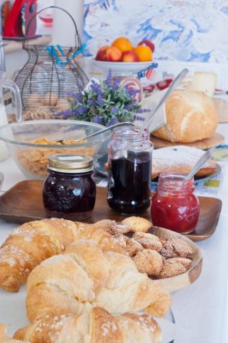 a table topped with bread and jam and other foods at B&B Il Pettirosso in Malonno