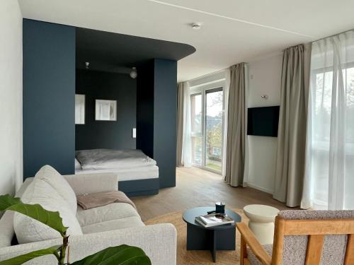 a living room with a couch and a bed at Design Color Apartments Leer in Leer