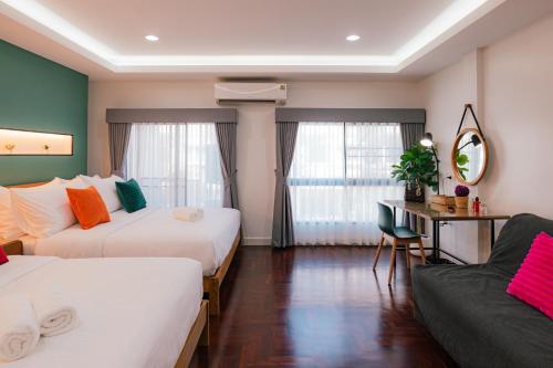 a hotel room with two beds and a couch at EXCLUSIVE SUKHUMVIT RESIDENCE, 3 Min BTS, Thonglor, 20 Guests in Bangkok