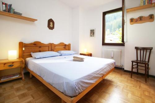 a bedroom with a bed and a desk and a window at WI-RO Mavignola - Trekking & Ski in Madonna di Campiglio