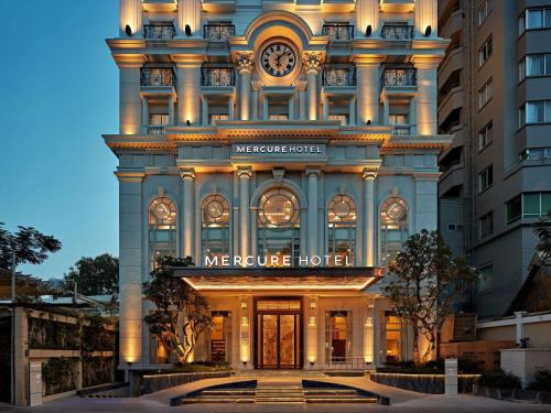 a facade of a hotel with a clock on it at Mercure Nha Trang Beach in Nha Trang