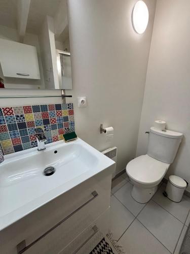 a white bathroom with a toilet and a sink at SWEET HOMES I Studio de Tata I Parking Gratuit in Angoulême