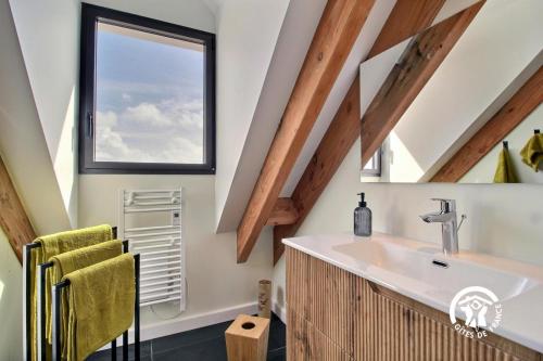 Un baño con lavabo y ventana. en Villa valerie, en Locmaria