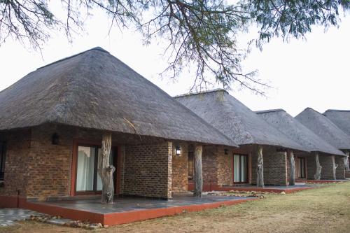 a row of houses with a thatched roof at Keleo Safari Lodge in Bela-Bela