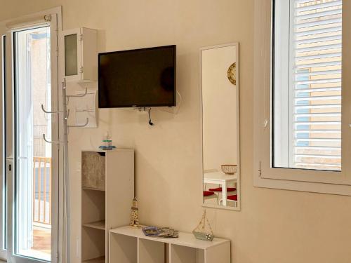 a living room with a flat screen tv on the wall at Da Nonna Concetta - 5 minutes walk from the beach in Donnalucata