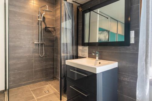 a bathroom with a sink and a shower at Maison calme, lumineuse & design in Sevran