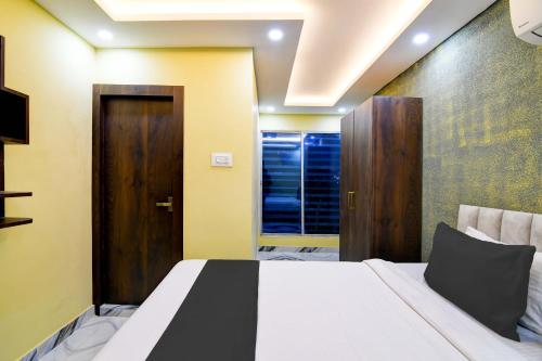 a bedroom with a bed and a wooden door at Hotel O The Crown in Kolkata