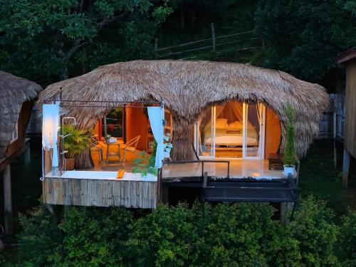 a small hut with a bed and a room at ดาวบนดินCamping in Ban Thung Phan Ha