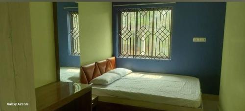 une petite chambre avec un lit et un miroir dans l'établissement Prime Inn Guest House, à Agartala