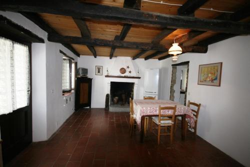 een eetkamer met een tafel en stoelen en een open haard bij Pradalara Holiday Home in Semelano di Sotto