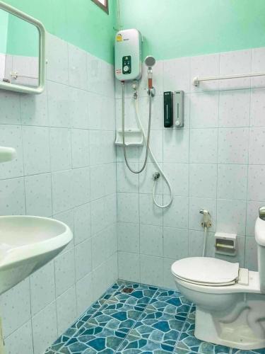 een badkamer met douche, toilet en wastafel bij Luigi Guest House & Kitchen in Sattahip
