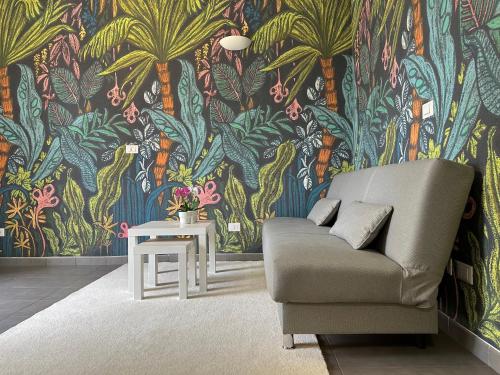 un soggiorno con un divano e una carta da parati tropicale di Villa Laura Home a Bologna
