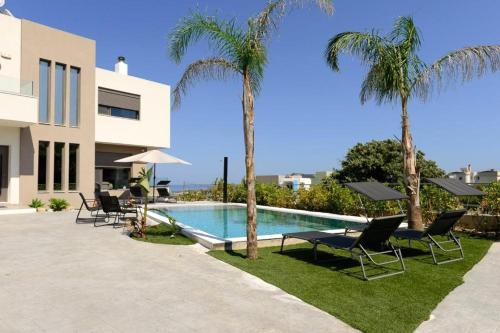 a villa with a swimming pool and palm trees at Aetheria Luxury Villa in Kalithies