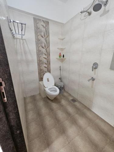 a bathroom with a toilet and a shower at StayGinie Baner in Pune
