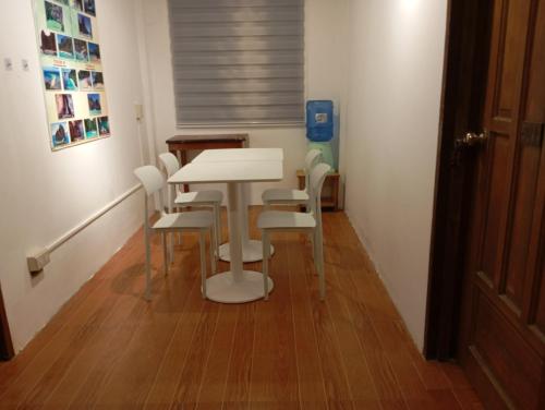 Una mesa y sillas blancas en una habitación. en Raje Residence, en El Nido