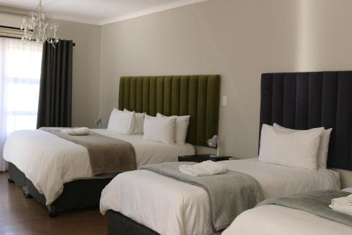 a hotel room with two beds and a chandelier at Luxury Heights Bed and Breakfast in Newcastle