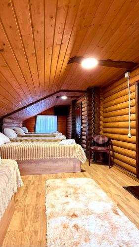 奥尔亚维奇克Drozdovichi Resort的客房设有三张床和木制天花板。