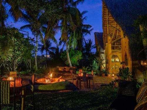 a patio with tables and chairs at night at Turtle Cove Self-Catering in Praia do Tofo