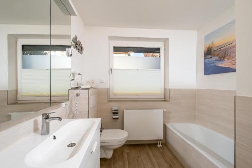 a bathroom with a sink and a toilet and a tub at Gästehaus "Kleines Stadtidyll" -Zimmer und Apartments in Geesthacht