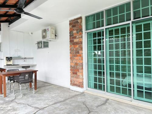a kitchen with a table and large glass doors at Cozy Family Room with Large Balcony in Nibung Tebal
