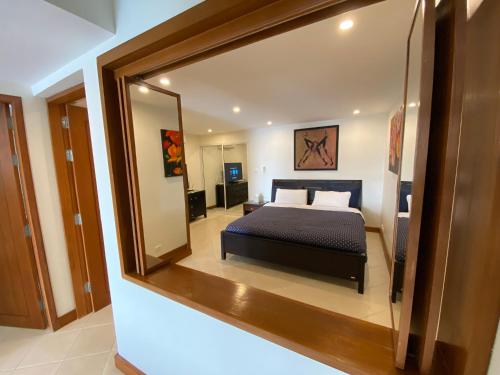 a bedroom with a bed and a large mirror at Andaman Hill Pool Seaview in Patong Beach