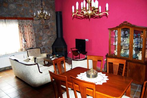 a living room with a dining table and a living room with pink walls at Escápate y desconecta en Son Soles! in Blacha