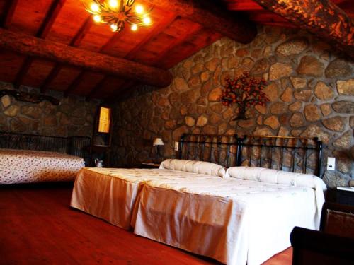 a bedroom with a bed in a stone wall at Escápate y desconecta en Son Soles! in Blacha