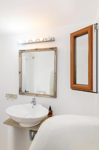 a bathroom with a sink and a mirror at Panormos Art Villas & Suites in Panormos