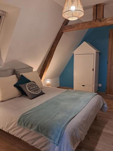 a bedroom with a bed with a pillow on it at Cottage normand, gîte à la campagne, au calme in Selles