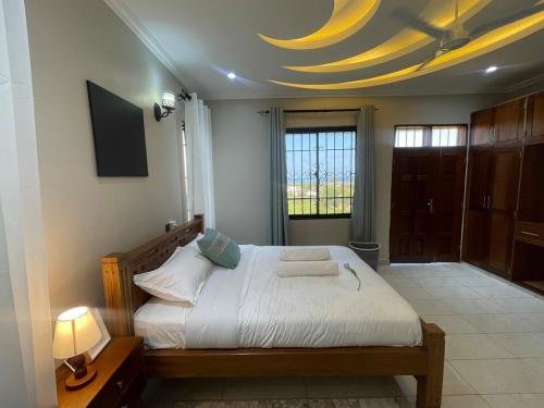 a bedroom with a large bed with a yellow ceiling at Zuri's Tidehouse, With Beach Access in Mombasa