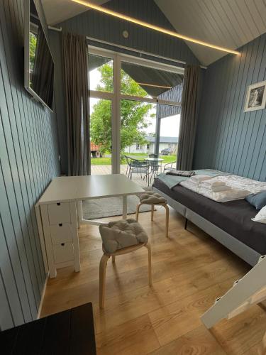 a bedroom with a bed and a desk and a table at Amma Jóna cottage in Hvolsvöllur