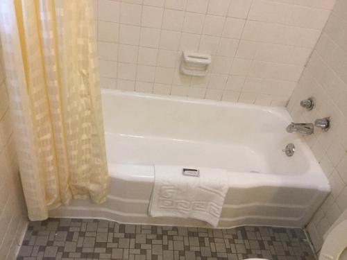 蘭伯頓的住宿－Budget inn，带淋浴的浴室配有白色浴缸。
