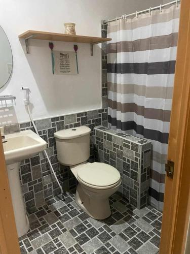 a bathroom with a toilet and a sink at Skipper Joes Resort in Dauis