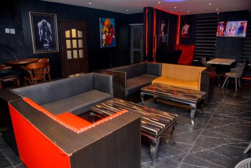 a lobby with couches and chairs and a bar at Triple Tee Luxury Hotel & Service Apartments Surulere in Lagos