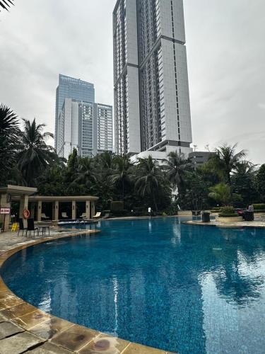 une grande piscine dans une ville avec de grands immeubles dans l'établissement 3br luxury sudirman tower ,next mall lippo nusantara, à Jakarta