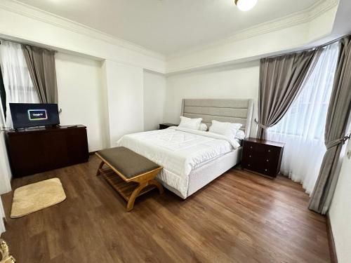une chambre avec un lit et une télévision dans l'établissement 3br luxury sudirman tower ,next mall lippo nusantara, à Jakarta