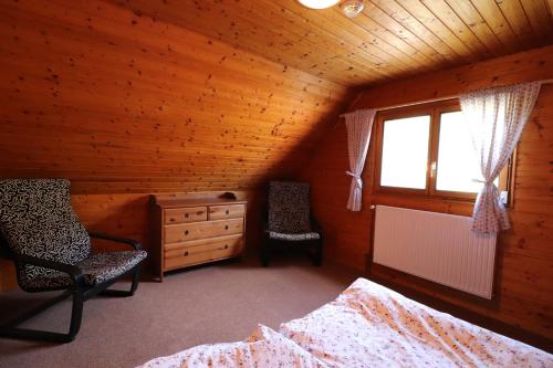 a attic room with two beds and a dresser and a window at Chata pod Paluchem in Vsetín